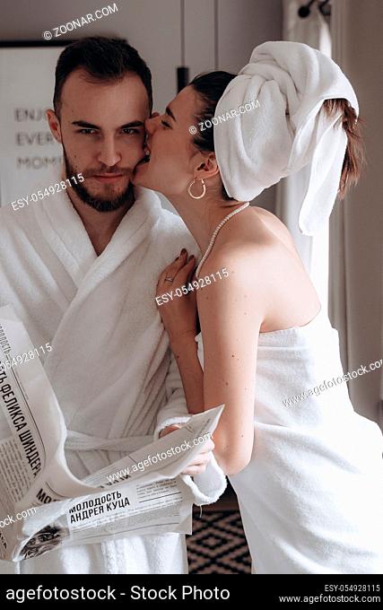 Guy in a white coat and a girl in a towel posing for the camera