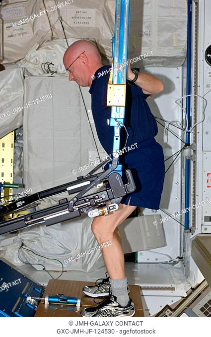 NASA astronaut Scott Kelly, Expedition 25 flight engineer, exercises using the advanced Resistive Exercise Device (aRED) in the Tranquility node of the...