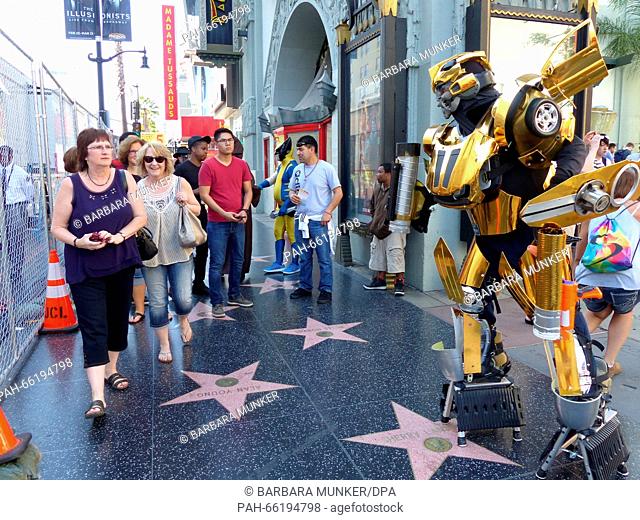 Als Transformers Bumblebee ist Daniel Kaslov (r) am 25.02.2016) auf den Walk of Fame in Hollwood (USA) unterwegs. Passanten fotografieren