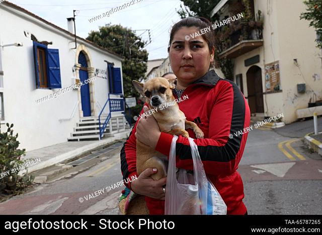 CYPRUS - DECEMBER 15, 2023: A local woman poses with her dog in the village of Bellapais (Beylerbeyi), north of Nicosia. The Turkish Republic of Northern Cyprus...