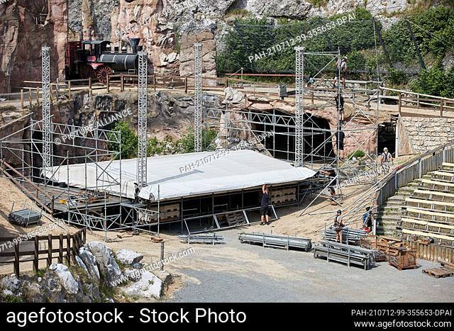 12 July 2021, Schleswig-Holstein, Bad Segeberg: Workers set up a concert stage in the Karl May round at Kalkberg. The Kalkberg Arena in Bad Segeberg is...