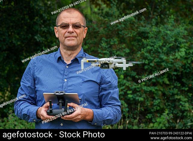02 July 2021, Saxony, Leipzig: Ralph Werner of the Quadrocopter flight school pilots a drone, a DJI Mavic Mini, in a park