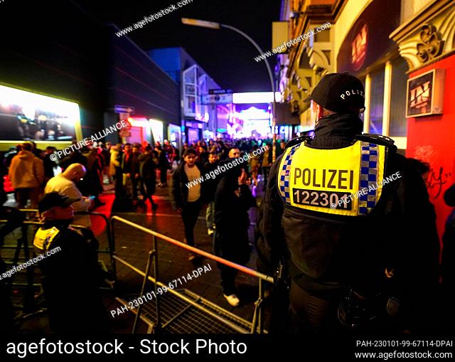 01 January 2023, Hamburg: Police officers control access to the Grosse Freiheit on New Year's Eve in the St. Pauli district. Photo: Marcus Brandt/dpa