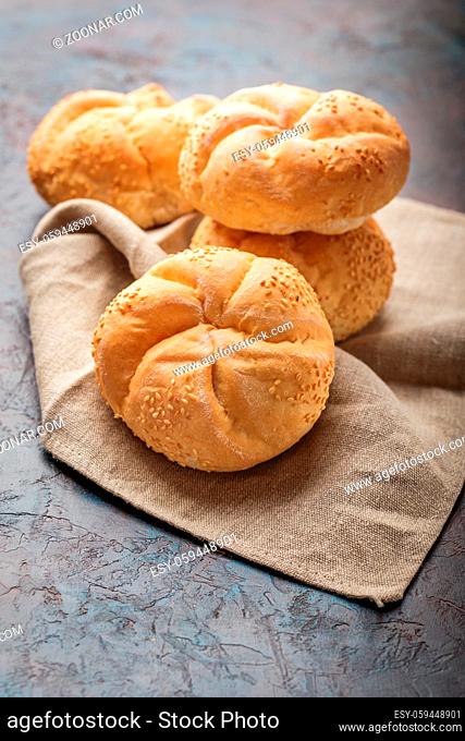 Delicious fresh buns with sesame seeds on a linen napkin