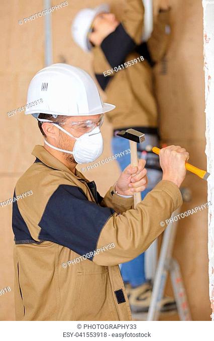 Workman using hammer and chisel