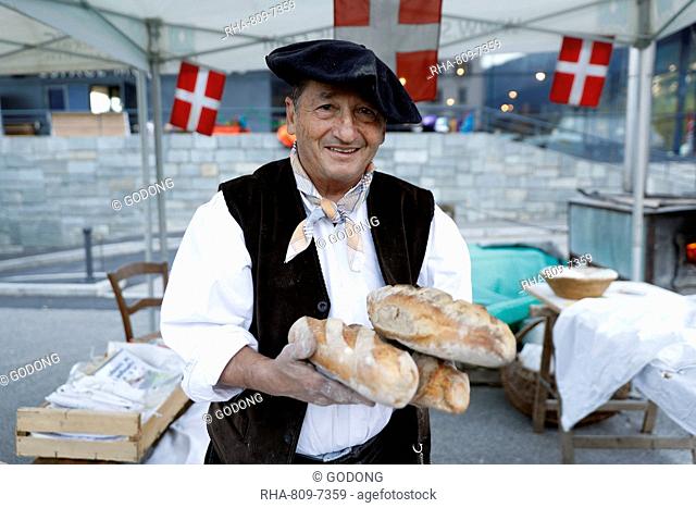 Baker with artisan bread, the agriculture fair (Comice Agricole) of Saint-Gervais-les-Bains, Haute Savoie, France, Europe