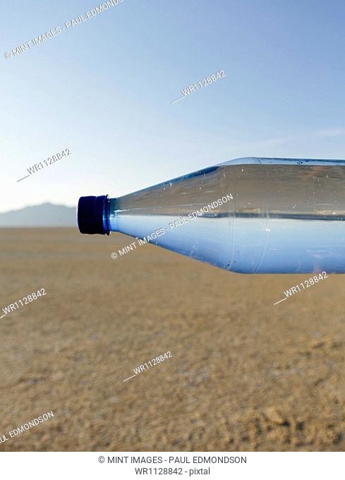 The landscape of the Black Rock Desert in Nevada. An essential element for survival. A bottle of water. Filtered mineral water. Sideways