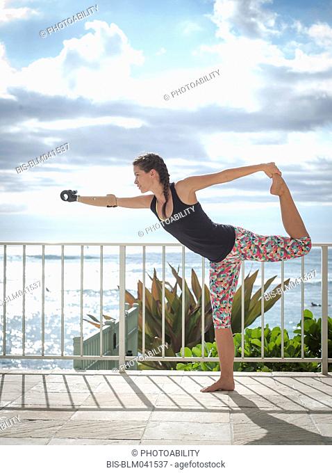 Mixed race amputee athlete stretching on balcony