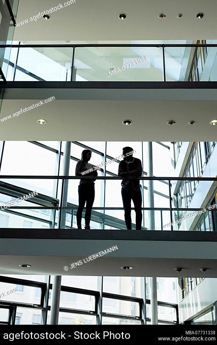 Young woman and young man in modern office building make break