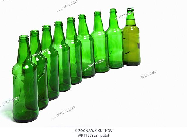 Empty glass bottles and one full in end of number