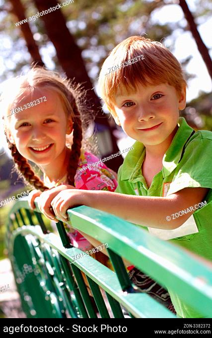 boy and girl standing on the bridge and smiling, outdoors