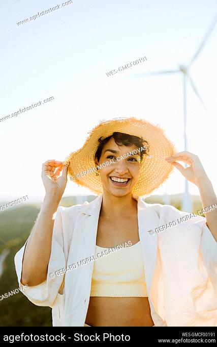 Happy woman holding hat