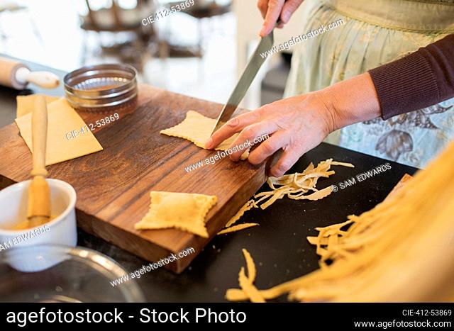 Close up woman cutting fresh homemade pasta