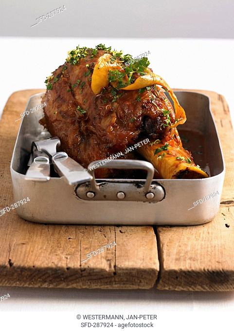 Veal shank with lemon in roasting tin