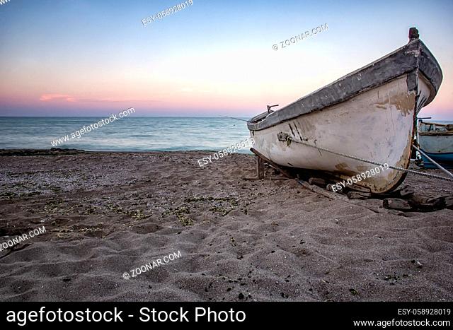 Conceptual view of the lonely boat on the sea beach. Feelings and mood