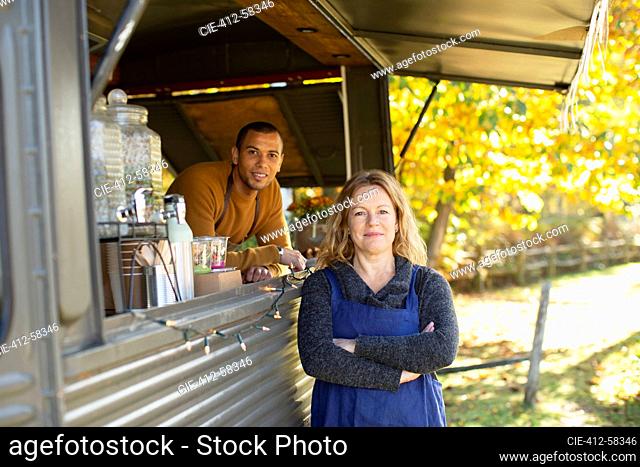Portrait confident food cart owners in autumn park