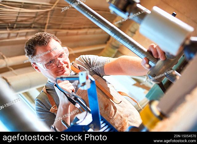 Schreiner Lehrling mit Schutzbrille arbeitet mit Holz in der Schreinerei Werkstatt