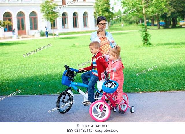 portrait of happy young family,  mother and  kids have fun in park