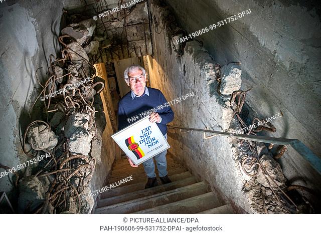 04 June 2019, Mecklenburg-Western Pomerania, Zurow: Dieter Luchs, collector of GDR shopping bags, holds a picture frame with a plastic bag of the League for...