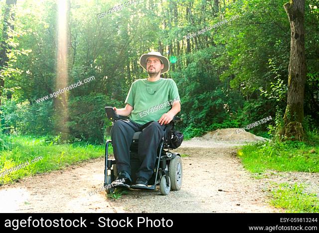 Laughing young handicapped man in a wheelchair