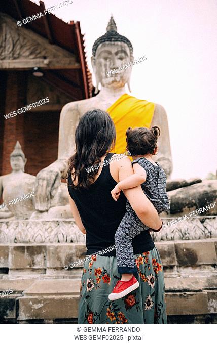 Thailand, Ayutthaya, back view of mother and little daughter visiting Wat Yai Chaya Mongkhon