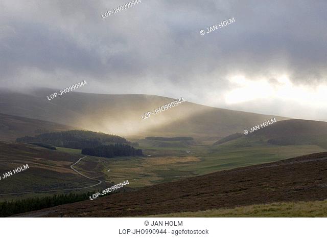 Scotland, Aberdeenshire, Glen Gairn, Light breaking through storm clouds in Glen Gairn