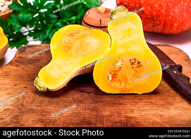 fresh pumpkin on a cutting kitchen wooden board, close up