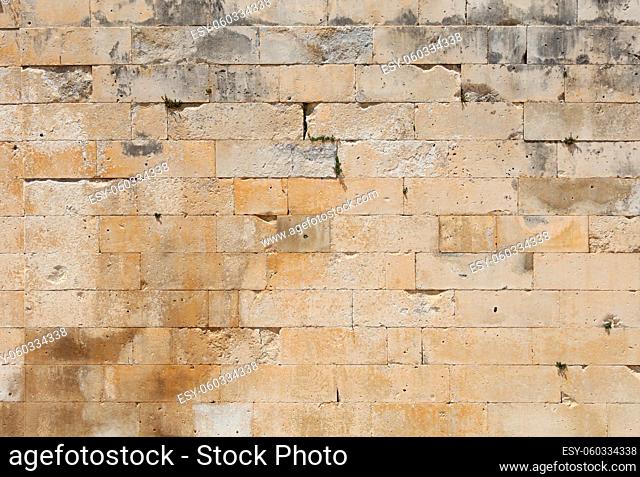 Wall of white and gray adarce travertine stone brick blocks, close up background texture, side view