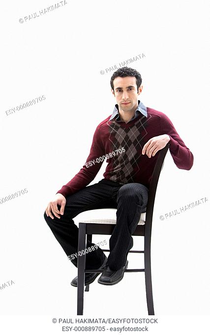 Handsome guy wearing business casual clothes sitting on a high chair, isolated