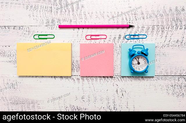 Blank notepads clips marker small alarm clock wooden vintage background