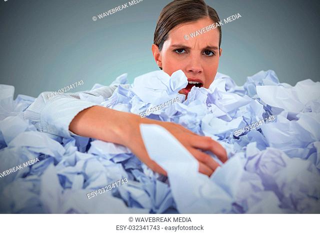 Composite image of portrait of unhappy businesswoman in heap crumpled paper