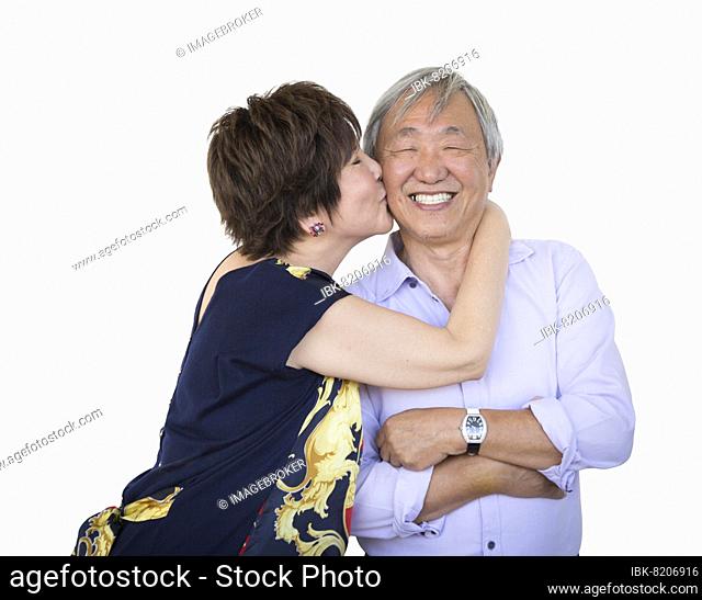 Attractive affectionate senior chinese couple isolated on a white background