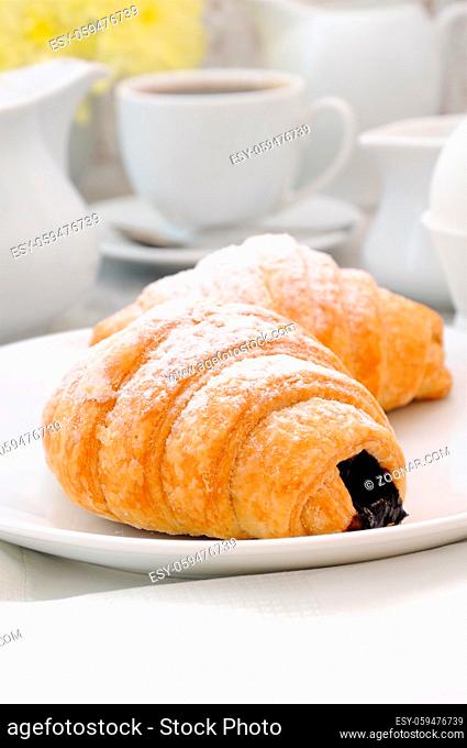 Croissants with chocolate filling cup and fresh morning coffee. Foreground close-up