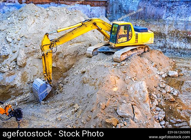 Big yellow excavator working at the construction site