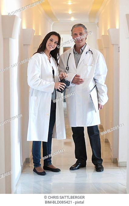 Hispanic doctors standing together in hospital corridor
