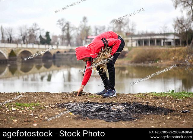 05 March 2020, Turkey, Edirne: A Syrian refugee collects firewood in the Turkish border town of Edirne on the river ""Tunca Nehri"" near the border crossing...