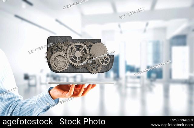 Metal gears and cogwheels mechanism or engine on white office background. Mixed media