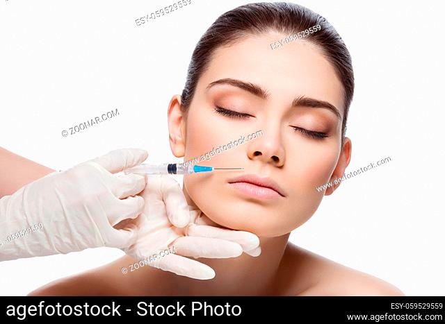 Beautiful young woman gets beauty injection in lips from sergeant. Isolated over white background