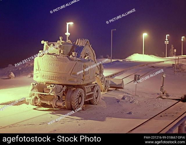 16 December 2023, Saxony-Anhalt, Schierke: Hoarfrost and snow cover an excavator on the Brocken. The mild temperatures of the past few days have caused the snow...