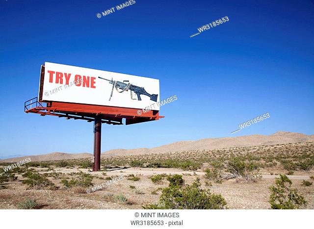 Large board advertising machine gun in the desert