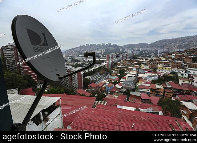 19 May 2020, Venezuela, Caracas: An antenna of the US television satellite operator DirectTV is hanging over the roofs after the operator announced its...