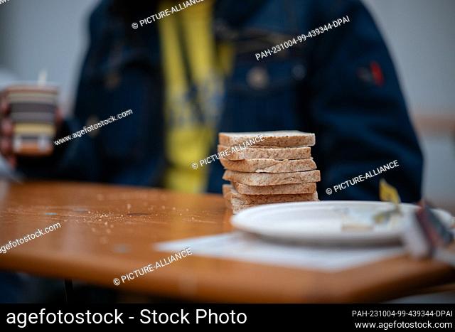 04 October 2023, Berlin: A stack of toast slices lie in front of Mansour El-Dschaber from Syria at the arrival center at the former Tegel Airport