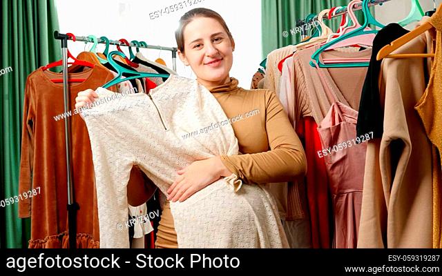 Smiling pregnant woman posing with beautiful dress for mothers and looking in camera