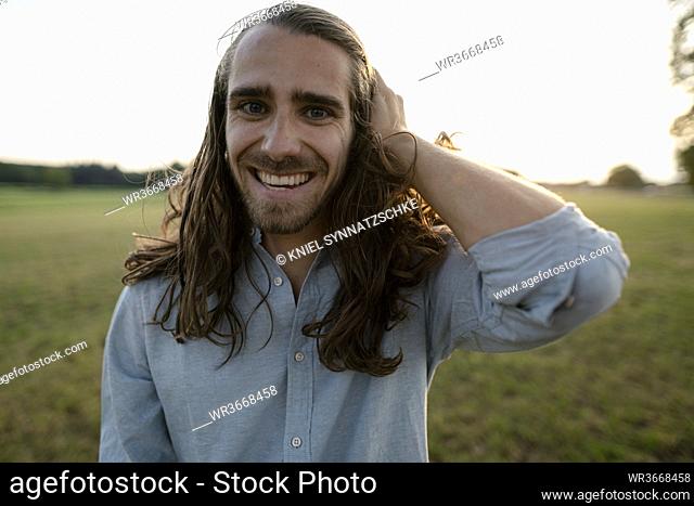 Portrait of a happy young man on a meadow in the countryside