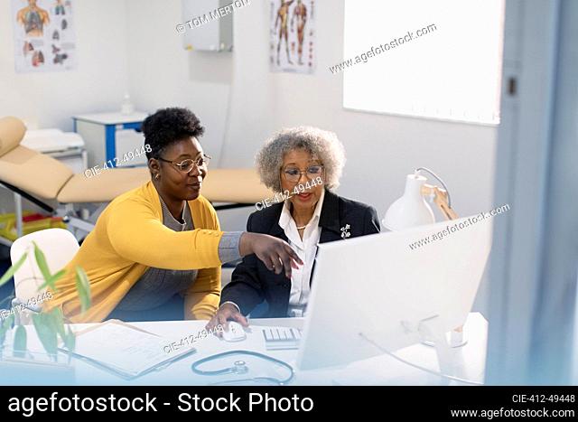 Female doctor and patient meeting at computer in doctors office