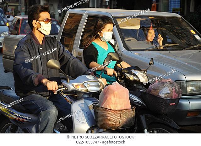 Chiang Mai (Thailand), people driving motorbikes with masks against pollution