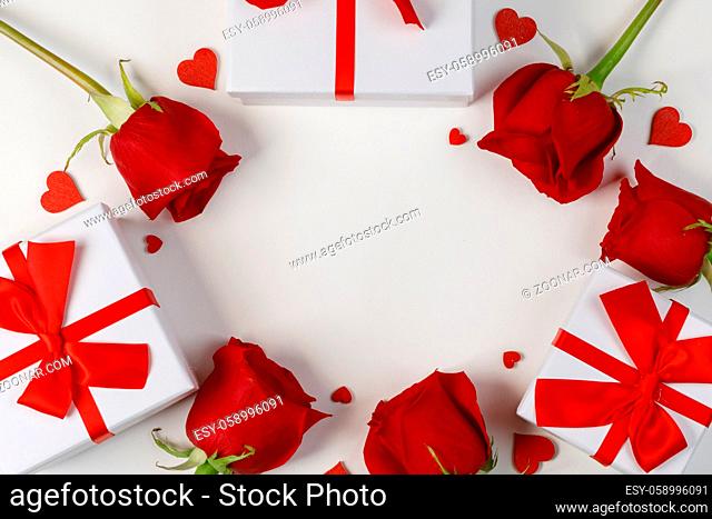 Red rose flowers gifts and red hearts composition on white background top view with copy space. Valentine's day, birthday, wedding, Mother's day concept