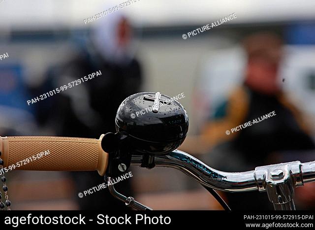 15 October 2023, Saxony-Anhalt, Oschersleben: A bicycle bell with a cross is attached to the steering wheel of a moped at the biker service