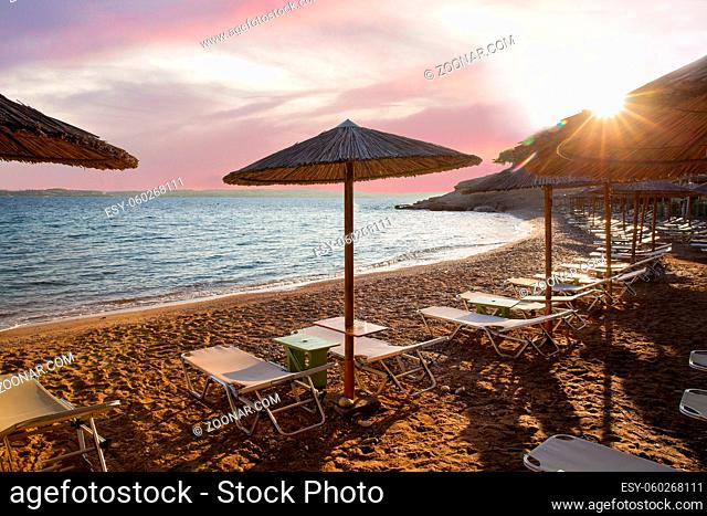 Cane awnings on Greek Islands and amazing sunrise on small beqch on fantastic ecologic Island Spetses Fantastic recreation on Greek islands