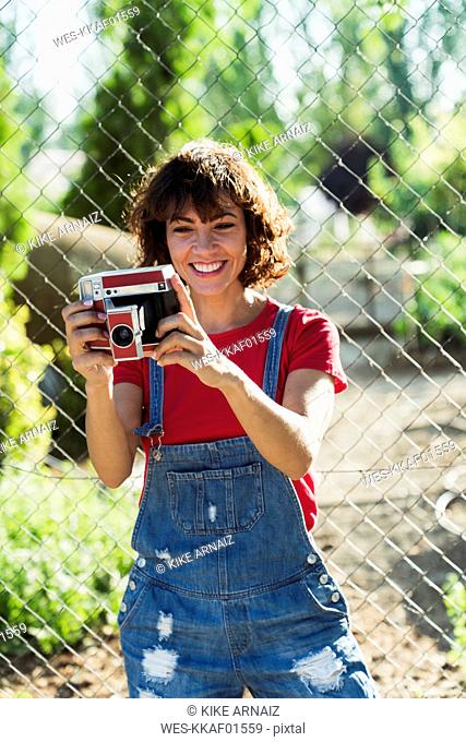 Portrait of smiling woman with instant camera